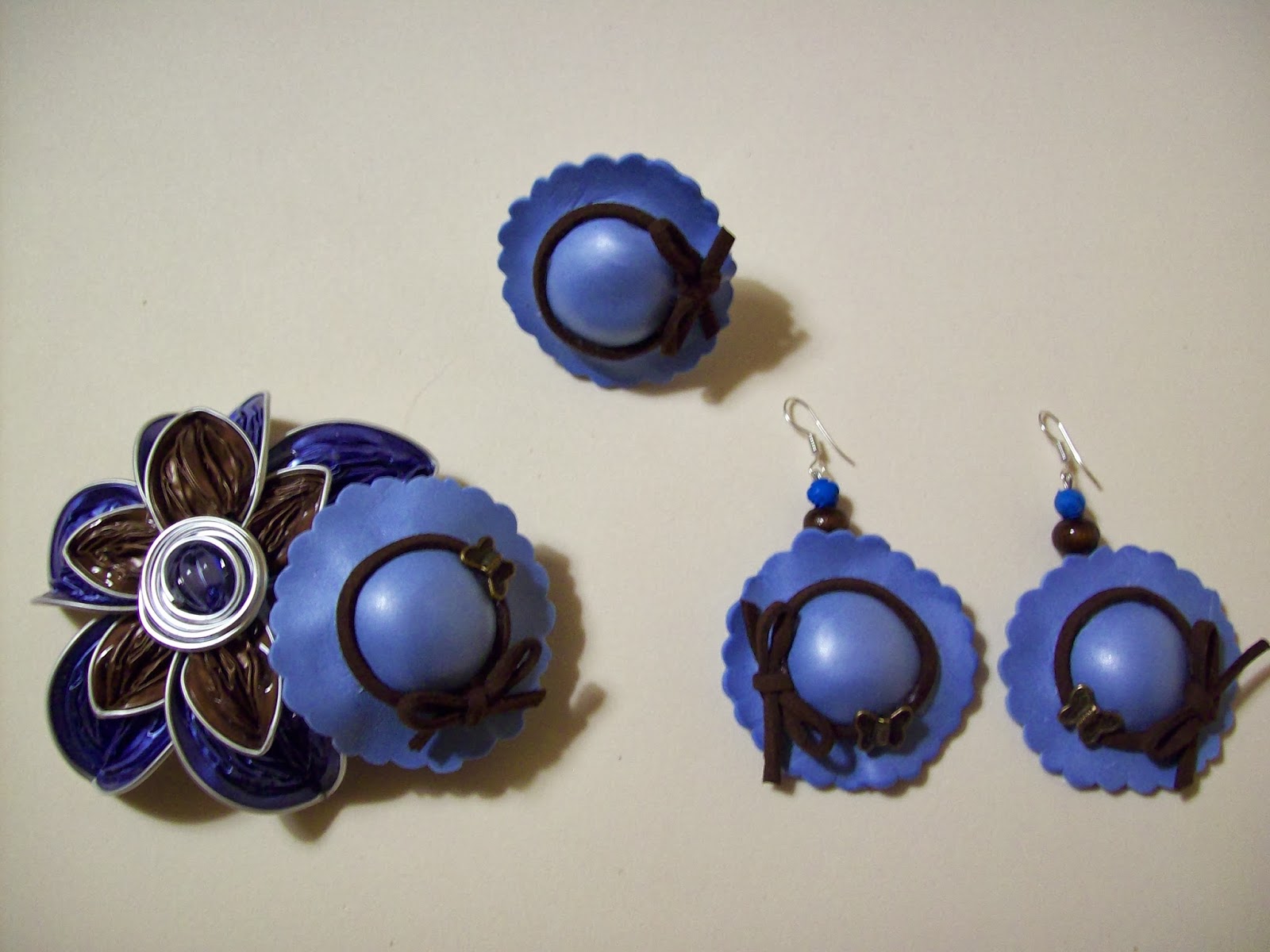 Conjunto de joyería artesanal con broche de flor y pendientes redondos en tonos azules y marrones